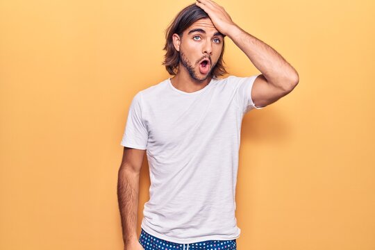 Young handsome man wearing casual clothes surprised with hand on head for mistake, remember error. forgot, bad memory concept.