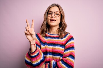 Young beautiful blonde girl wearing glasses and casual sweater over pink isolated background...