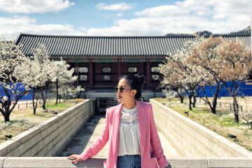 Young beautiful woman visiting the beautiful Gyeongbokgung Palace, Seoul, South Korea on a sunny day
