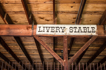 Livery Stable. Interior of barn with livery stable sign. - Powered by Adobe
