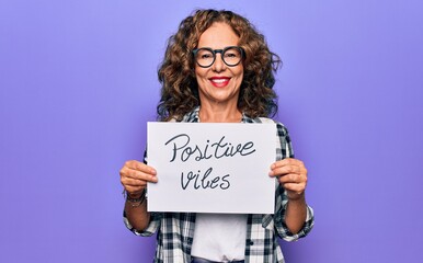 Middle age woman asking for optimistic attitude holding paper with positive vibes message looking...
