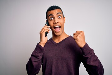 Young handsome african american man having conversation talking on the smartphone screaming proud and celebrating victory and success very excited, cheering emotion