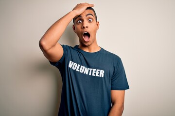 Young handsome african american man volunteering wearing t-shirt with volunteer message surprised...