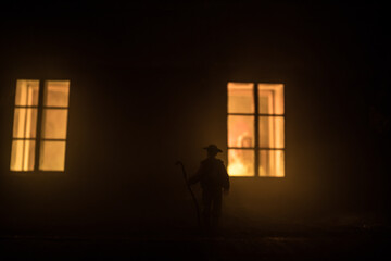 Old house with a Ghost in the forest at night. Horror silhouette at the window. Old building in forest. Surreal lights. Horror Halloween concept