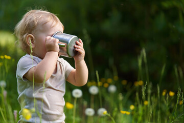 child with a mug of drink outdoors