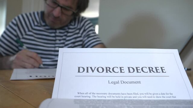 Furious man signing a divorce decree document in a rush.