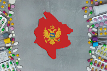 The Montenegro State began research for treatment and medicine to combat the pandemic outbreak disease coronavirus. Medicine, pills, needles, syringes and Montenegro map and flag on gray background.