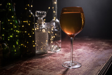 Goblet of white wine on wooden table on wooden wall background