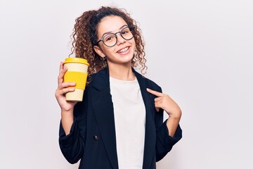 Beautiful kid girl with curly hair wearing business clothes and glasses holding takeaway cup of coffee pointing finger to one self smiling happy and proud