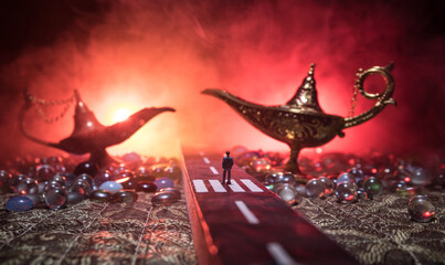Silhouette of a man standing in the middle of the road on a misty night with giant Antique Aladdin...