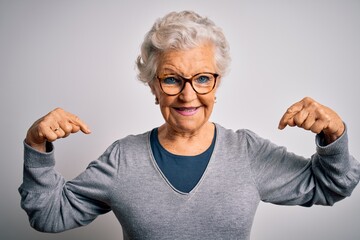 Senior beautiful grey-haired woman wearing casual sweater and glasses over white background looking confident with smile on face, pointing oneself with fingers proud and happy.