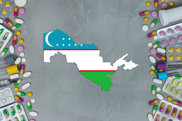 Obraz premium The Uzbekistan State began research for treatment and medicine to combat the pandemic outbreak disease coronavirus. Medicine, pills, needles, syringes and Uzbekistan map and flag on gray background.