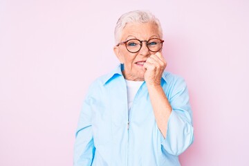 Senior beautiful woman with blue eyes and grey hair wearing glasses looking stressed and nervous with hands on mouth biting nails. anxiety problem.