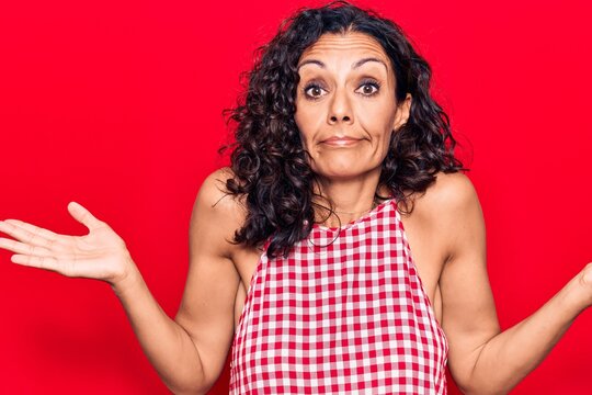 Middle age beautiful woman wearing casual sleeveless t shirt clueless and confused with open arms, no idea and doubtful face.