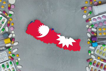 The Nepal State began research for treatment and medicine to combat the pandemic outbreak disease coronavirus. Medicine, pills, needles, syringes and Nepal map and flag on gray background.