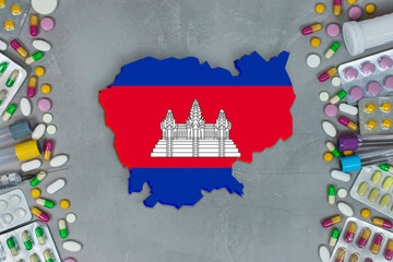 The Cambodia State began research for treatment and medicine to combat the pandemic outbreak disease coronavirus. Medicine, pills, needles, syringes and Cambodia map and flag on gray background.