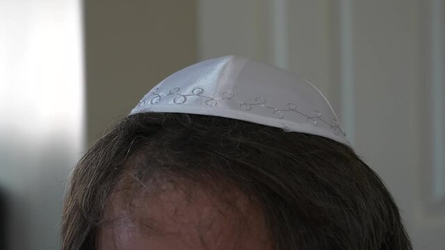 Closeup on the kippah of a Jewish man.