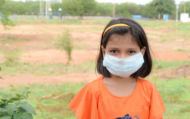 indiaLittle girl has face mask protect herself from Coronavirus,New Normal child leave the house with a mask on her nose for safety outdoor activity after COVID-19 outbreak,illness or Air pollution
