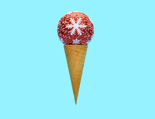 ice cream cone with red Christmas decorative ball on top on blue background