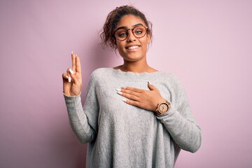 Young beautiful african american girl wearing sweater and glasses over pink background smiling...
