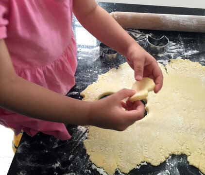 Niña aprendiendo a cocinar galletitas