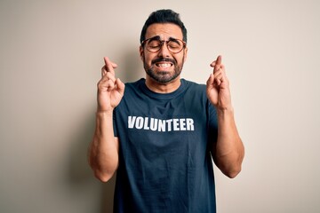 Handsome man with beard wearing t-shirt with volunteer message over white background gesturing...