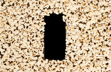 Popcorn scattered around the screen, black modern computer tablet, isolated on white background. Mockup phone with black copy space