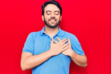 Young hispanic man wearing casual clothes smiling with hands on chest, eyes closed with grateful gesture on face. health concept.