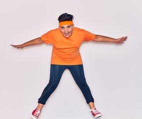 Adorable hispanic kid wearing sportswear smiling happy. Jumping with smile on face over isolated white background