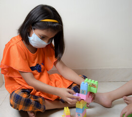 kids are playing  indoor games with wearing mask during covid 19 pandemic