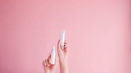 hand hold cosmetic skincare on pink background.beauty banner.