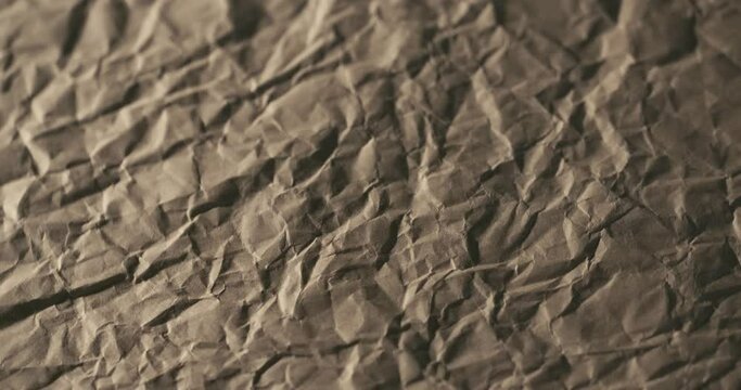 4K brown crumpled craft paper texture background, low poly mountains rotating slowly in macro