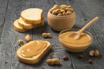 Fototapeta na wymiar Peanut paste with bread and peanut fruit on a wooden table.