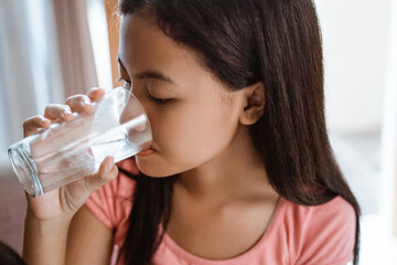 teen girl having a glass of water drink at home