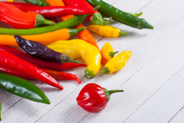 chili pepper selection on white wood table background