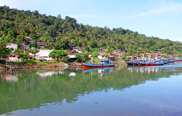 Fototapeta na wymiar Colorful blue and red fishing boats in the Batang Arau river and port in Padang City in West Sumatra, Indonesia.