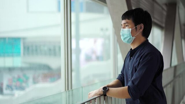 young asian man wearing medical mask for prevention from coronavirus (Covid-19) pandemic in the city. new normal concepts