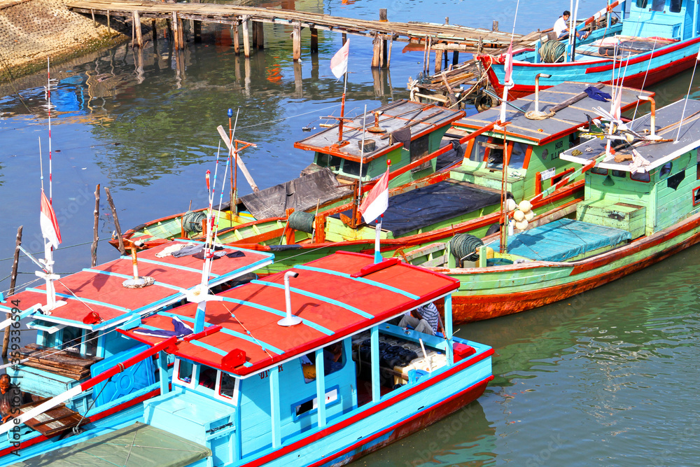 Wall mural Colorful blue and red fishing boats in the Batang Arau river and port in Padang City in West Sumatra, Indonesia.