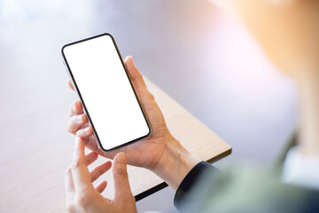 cell phone mockup image blank white screen.woman hand holding texting using mobile on desk at coffee shop.background empty space for advertise.work people contact marketing business,technology