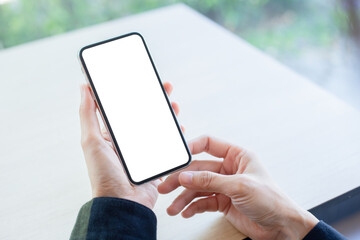cell phone mockup image blank white screen.woman hand holding texting using mobile on desk at coffee shop.background empty space for advertise.work people contact marketing business,technology
