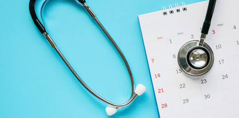 Stethoscope with calendar page date on blue background doctor appointment medical concept