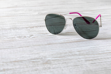 Sunglasses on a wooden table. Close up.