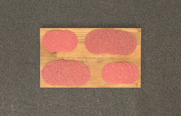 On the background grey stone ground, salami varieties at the top of the cutting board.