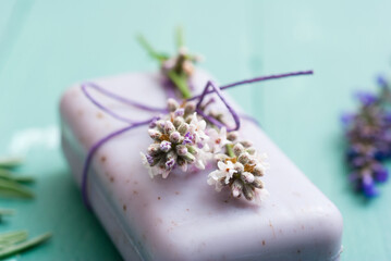Obraz na płótnie Canvas lavender soap and flowers on worn blue painted wooden table background