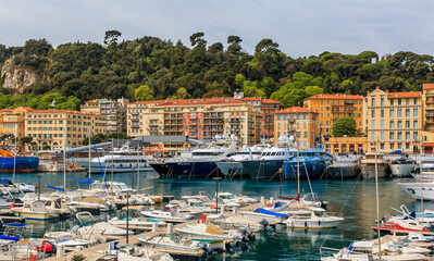 Fototapeta na wymiar Panoramic view of boats in the marina and waterfront buildings in Nice port on the Mediterranean Sea, Cote d'Azur, France