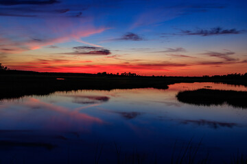 Fototapeta premium orange sunset over blue swamp water