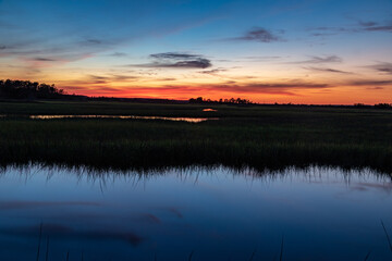 orange sunset over blue swamp water