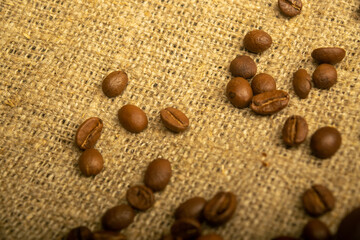 Coffee beans on a background of homespun fabric with a rough texture. Close up.