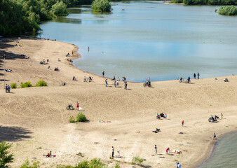 A beach with people swimming, photographed from afar