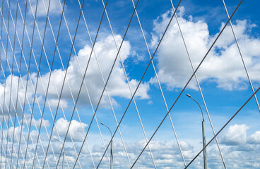 View of the sky with clouds through the lattice of the bridge